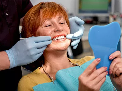 Patient receiving dental examination from dentist in professional dental office setting.