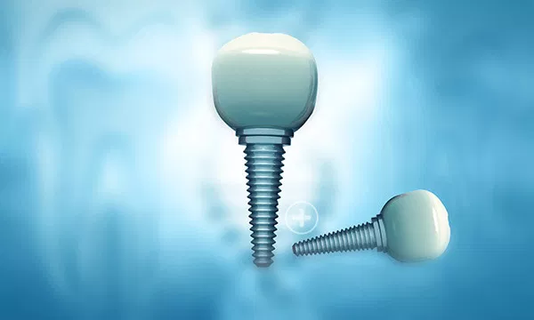 Two dental implants with screw posts against a blue blurred background.